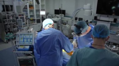 KYIV, UKRAINE - 25 Mayıs 2022: Nörocerrah ventrikül-peritoneal shunting yapar. Şant tıbbi kondüktörü. Ventrikül-periton ameliyatı. Şant rehberi ile yan yana. Editör görüntüsü.