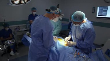 KYIV, UKRAINE - 25 Mayıs 2022: Nörocerrah ventrikül-peritoneal shunting yapar. Şant tıbbi kondüktörü. Ventrikül-periton ameliyatı. Şant rehberi ile yan yana. Editör görüntüsü.