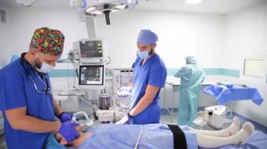 VINNYTSIA, UKRAINE - 21 HAZİRAN 2022: cerrahi bir operasyon için hazırlık. Anestezi uzmanı hastaya anestezi uygular. Doktorlar hastayı ameliyata hazırlıyorlar - editörlük görüntüleri.