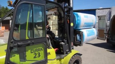 KYIV, UKRAINE - AĞUSTOS 02, 2021: Endüstriyel depo Elektrikli bir forklift arabaya mal yükler. Depo stoku - editörlük görüntüleri