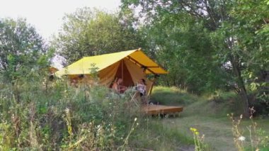 MOGYLIVKA, UKRAINE - AUGUST 21, 2022: Budget glamping for family outdoor recreation. Glamping terrace in the forest. Glamping site in the woods on a calm afternoon.