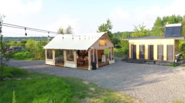MOGYLIVKA, UKRAINE - AUGUST 21, 2022: Budget glamping for family outdoor recreation. Glamping terrace in the forest. Glamping site in the woods on a calm afternoon.
