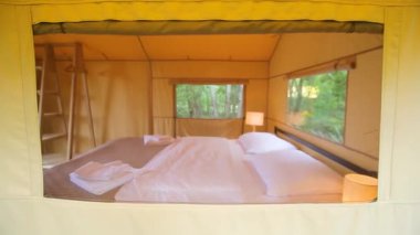 Budget glamping for family outdoor recreation. Glamping terrace in the forest. Glamping houses, rural landscape, tent houses.