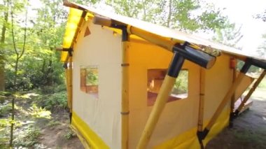 Budget glamping for family outdoor recreation. Glamping terrace in the forest. Glamping houses, rural landscape, tent houses.