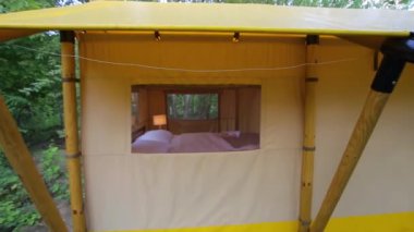 Budget glamping for family outdoor recreation. Glamping terrace in the forest. Glamping houses, rural landscape, tent houses.