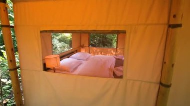 Budget glamping for family outdoor recreation. Glamping terrace in the forest. Glamping houses, rural landscape, tent houses.