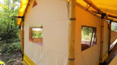 Budget glamping for family outdoor recreation. Glamping terrace in the forest. Glamping houses, rural landscape, tent houses.