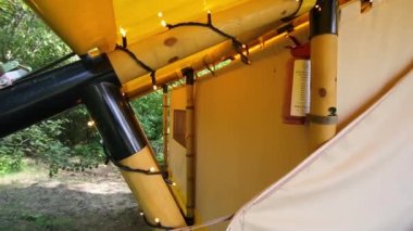 Budget glamping for family outdoor recreation. Glamping terrace in the forest. Glamping houses, rural landscape, tent houses.