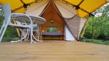 Budget glamping for family outdoor recreation. Glamping terrace in the forest. Glamping houses, rural landscape, tent houses.