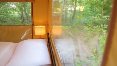 Budget glamping for family outdoor recreation. Glamping terrace in the forest. Glamping houses, rural landscape, tent houses.