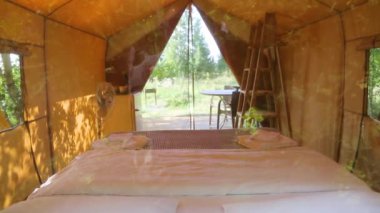 Budget glamping for family outdoor recreation. Glamping terrace in the forest. Glamping houses, rural landscape, tent houses.