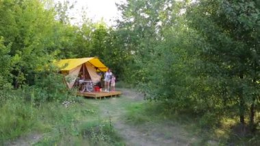 MOGYLIVKA, UKRAINE - AUGUST 21, 2022: Budget glamping for family outdoor recreation. Glamping terrace in the forest. Cute fabric tents, in a forest environment in an eco camp - editorial footage