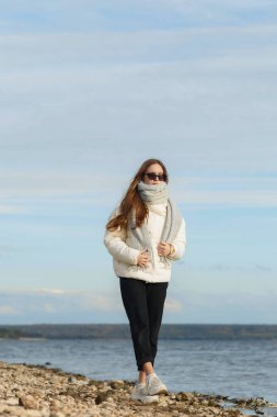 Açık renk ceketli ve Volga kıyısında gri atkısı olan bir kız.