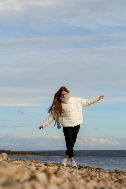 Açık renk ceketli ve Volga kıyısında gri atkısı olan bir kız.