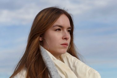 Açık renk ceketli ve Volga kıyısında gri atkısı olan bir kız.