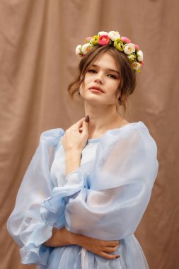 Mavi elbiseli, çiçekli bir kızın portresi.