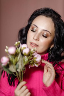 Çiçekli, pembe bluzlu bir kız.