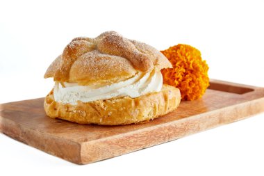 Meksika 'da ölüm bayramı. Tahta tahtada ve beyaz arka planda hamur işi kreması ile doldurulmuş ölüler ekmeği.