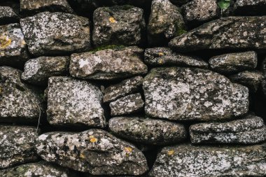 Taş bir duvarın arka planı, yakın plan. Betonda büyük ve küçük çok renkli taşların dokusu.