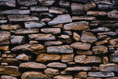 Taş bir duvarın arka planı, yakın plan. Betonda büyük ve küçük çok renkli taşların dokusu.