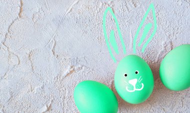 Açık dokulu arka planda tavşan kulaklı paskalya yumurtası. Üst Manzara. Boşluğu kopyala