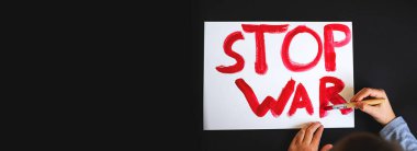 Çocuğun eli siyaha beyaz üzerine kırmızı bir ceket yazdı. Savaş kavramı yok. Pankart. Boşluğu kopyala.