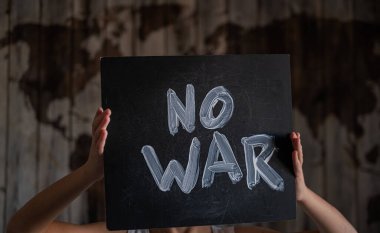 Çocuğun elinde bir poster var. Dünya haritasının arka planında savaş yok. Kavram.