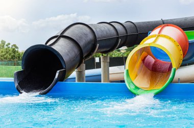 Yazın mavi berrak su ve su kaydırağıyla yüzme havuzunun manzarası