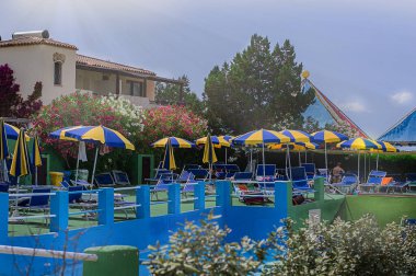 Yazın su parkındaki sarı mavi güneşlik manzarası. Sardunya.