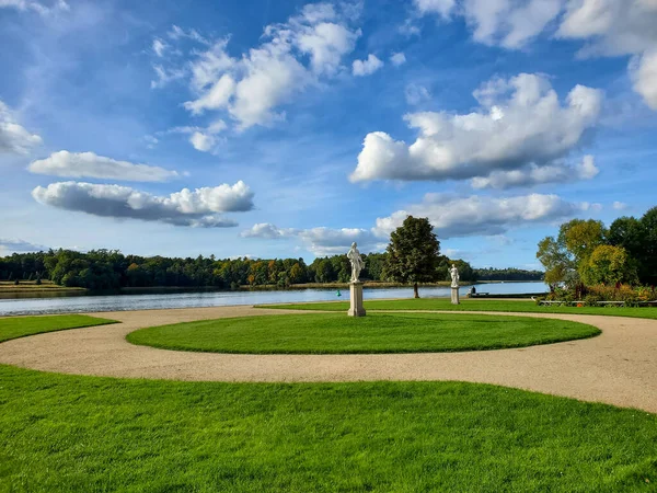 Gyönyörű táj park naplementekor, zöld gyep egy nyári napon, felhős ég, lenyugvó nap — Stock Fotó