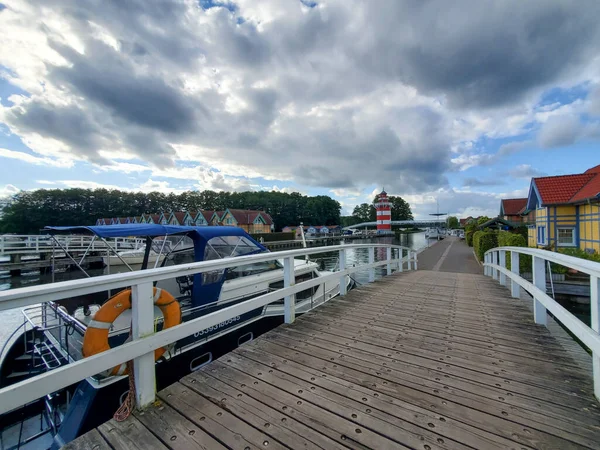 Ponte de madeira com grades sobre a água em um dia claro ensolarado nublado — Fotografia de Stock