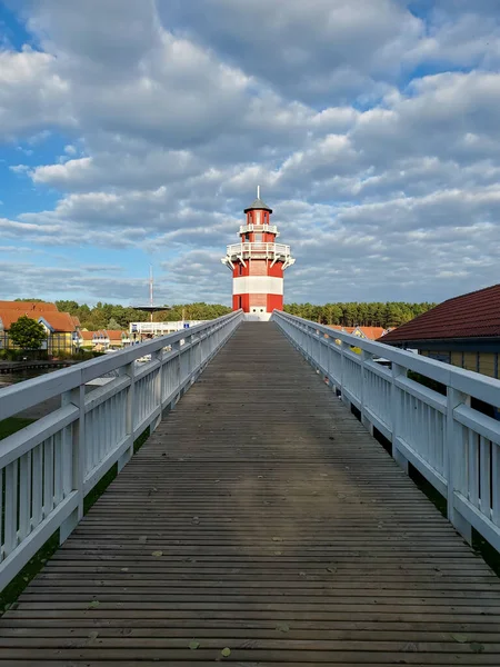 Дерев'яний мальовничий міст до маяка, червоно-білий маяк, рухаючись вперед до мети, Рейнсберг — стокове фото