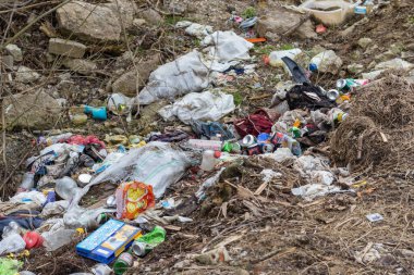 Toprağı ve havayı kirleten tarlaya çöp atılmış.