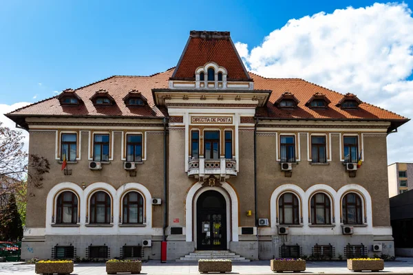 Bacau, Romanya, 02 Mayıs 2021: Pencerelerinde 2 Romen bayrağı bulunan simetrik Postane binasının önündeki fotoğraf