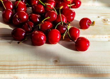 Tahta bir masada taze kırmızı kirazların dokusunu gösteren yakın plan fotoğraf; boşluğu kopyala