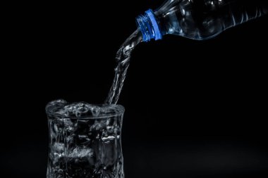 Şişe suyu bardağa döküldü.