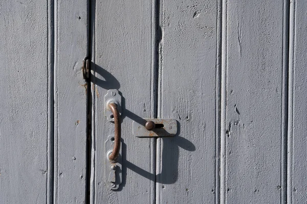 old wooden doors with peeling off paint and old rusty door handles