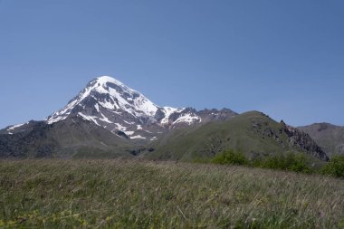 Gürcistan, Kazbegi 'nin dağ sıraları, iki dağın üçgen şeklini oluşturduğu ve üzerlerinde beyaz karla kaplı bir dağ baharatı bulunan yer.
