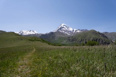 Gürcistan, Kazbegi 'nin dağ sıraları, iki dağın üçgen şeklini oluşturduğu ve üzerlerinde beyaz karla kaplı bir dağ baharatı bulunan yer.