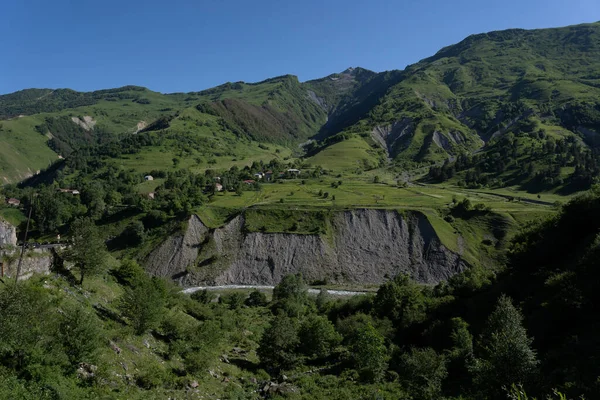 ジョージア地方の緑豊かな山々に青い空と遠くの道があり — ストック写真