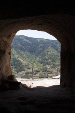 Etrafının karanlık olduğu bir mağara ama delikte dağı görebilirsin.