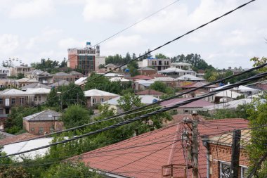 Arkasında birçok çatı ve bina görebileceğiniz bir sürü elektrik ve internet kablosu var.
