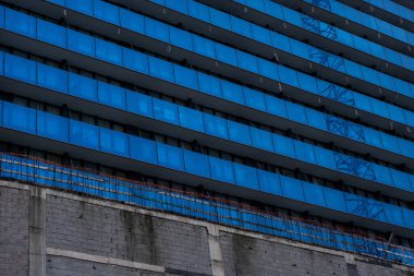 İlginç bir desen ve süs oluşturan çok büyük bir apartmanın yakın çekimi.,