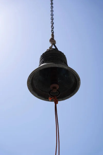 Grande Sino Metal Fixado Uma Corda Pendurado Sobre Fundo Céu — Fotografia de Stock