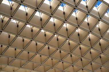 İlginç bir bina dizaynı farklı bir desen oluşturuyor ve arka plan mavi bir gökyüzü.