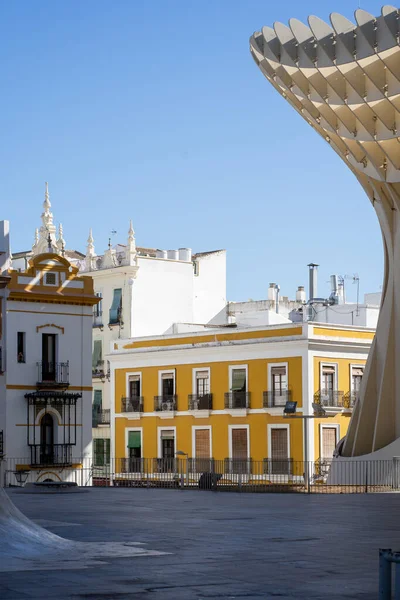 An interesting building design that forms a different pattern and the background is a blue sky and you can see a bright yellow building