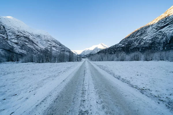 Een Rechte Onverharde Weg Bergen Bedekt Met Witte Sneeuw Maar — Stockfoto
