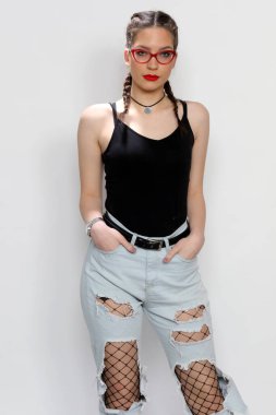 Stüdyoda izole edilmiş arka planda poz veren çekici beyaz bir kız. Tarz, trendler, moda konsepti.