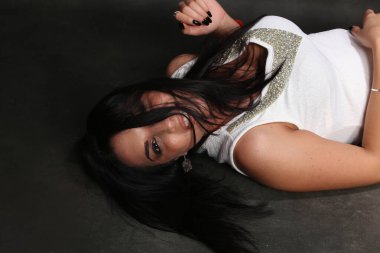 Stüdyoda poz veren güzel, göz kamaştırıcı, siyah saçlı beyaz kız. Tarz, trendler, yaşam tarzı, cazibe. Moda konsepti.