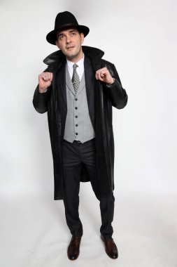 Soyutlanmış arka planda poz veren orta yaşlı yakışıklı bir gangster. Tarz, zarafet, iş, beyefendi, moda konsepti.